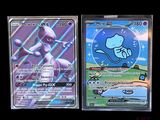 two pokemon cards sitting side by side on a black surface