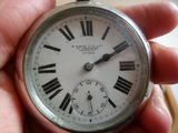 quelqu'un tient une montre à gousset en argent avec des chiffres romains.