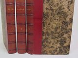 trois livres rouges superposés sur une surface blanche