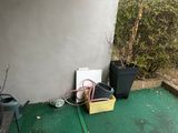a green floor with a potted plant and a hose on it