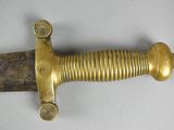 a close up of a sword on a table with a white background