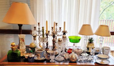 une table sur laquelle sont disposés de nombreux objets en argent et en verre