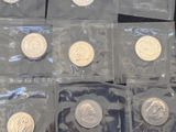 six different types of silver coins in plastic bags on a black surface