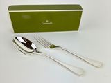 two forks and a spoon in front of a green box