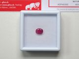 a close up of a red ruby stone in a white box