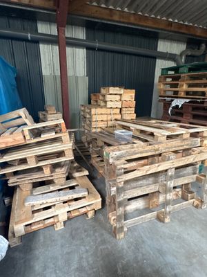 de nombreuses palettes de bois empilées dans un entrepôt