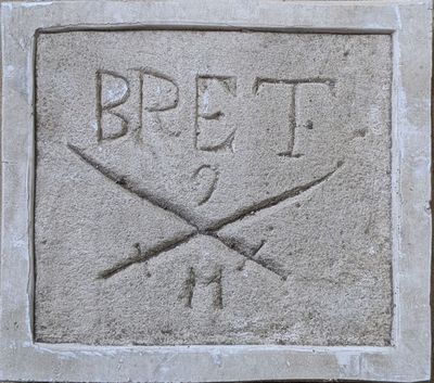 a stone plaque with a pair of scissors on it