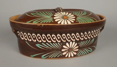 une image représentant un bol marron et vert orné de fleurs