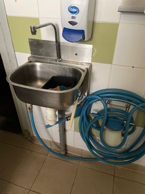 a sink with a hose next to it in a bathroom