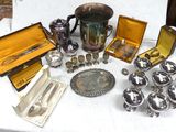 a lot of silver items on a table with a white table cloth