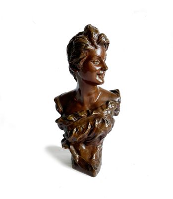 buste en bronze représentant une femme tenant un oiseau, sur fond blanc