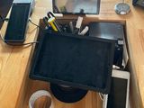 un homme debout devant un bureau sur lequel se trouvent un ordinateur portable et un écran