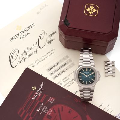 une photo d'une montre Rolex posée sur une table, à côté d'un certificat
