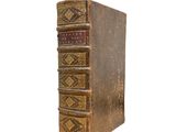 an old book sitting on top of a white surface