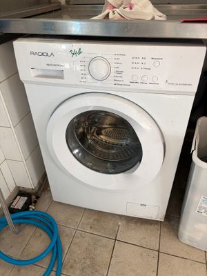 une machine à laver et une poubelle dans une cuisine
