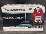 Le carton d'un aspirateur rouge et noir est posé sur la table.