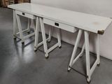 deux tables blanches montées sur roulettes dans une pièce