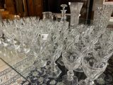 a lot of wine glasses sitting on a glass table