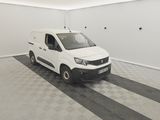 La camionnette blanche est garée dans le garage de l'immeuble.