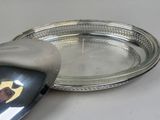 a silver plate with a spoon and a spoon rest on it