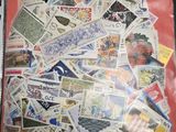un sachet de timbres posé sur une table, sur fond rouge