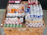 a wooden crate filled with bottles of soda and water
