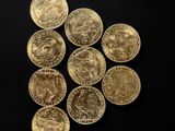 a close up of a pile of gold coins on a black surface