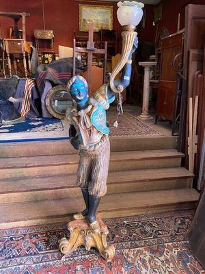 a statue of a man holding a lamp in his hand