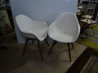 two white chairs sitting next to each other in a room
