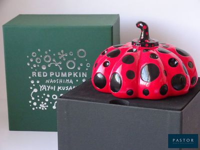 a red and black ladybug sitting on top of a black box