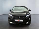 the front of a black car in a room with a white wall