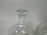 two glass vases sitting next to each other on a table