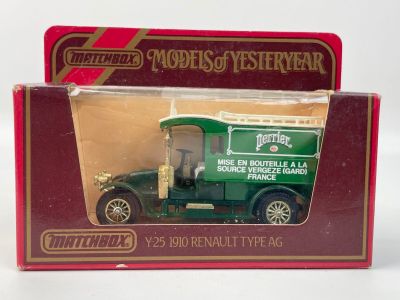 un petit camion vert dans une boîte rouge posée sur une surface blanche