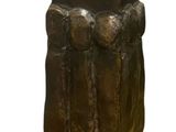 statue of a man with a hat on his head sitting on top of a rock