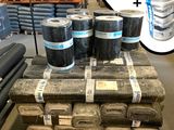 de nombreux rouleaux de tissu sur une palette dans un entrepôt