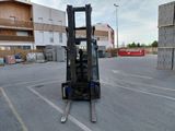 a forklift in a parking lot with a building in the background