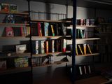 a book shelf with many books on it in a dark room