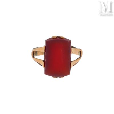 un gros plan d'une bague en pierre rouge sur fond blanc
