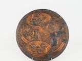 an old metal plate with a design of people and animals on it