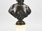 a bronze bust of a woman on a pedestal