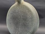 a gray vase that is sitting on a table