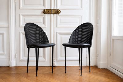 deux chaises noires placées devant une porte blanche