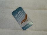 a white towel with a tag on it next to a toothbrush