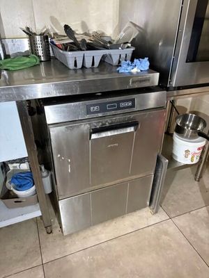 a stainless steel dishwasher in the middle of a kitchen