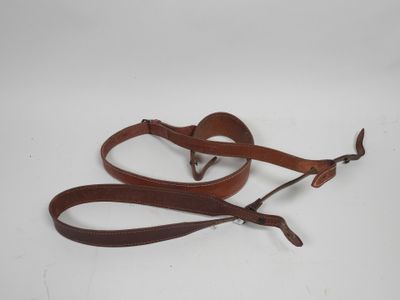 a pair of brown leather leashes on a white background
