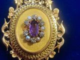 an image of a gold and amethoral broochle with pearls on it