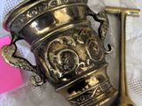 a silver cup and a gold spoon on a table