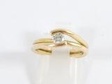 a close up of a gold ring with a diamond on top