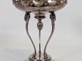 an antique silver plate on a stand on a white background