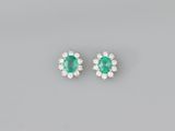 a pair of emerald and diamond earrings